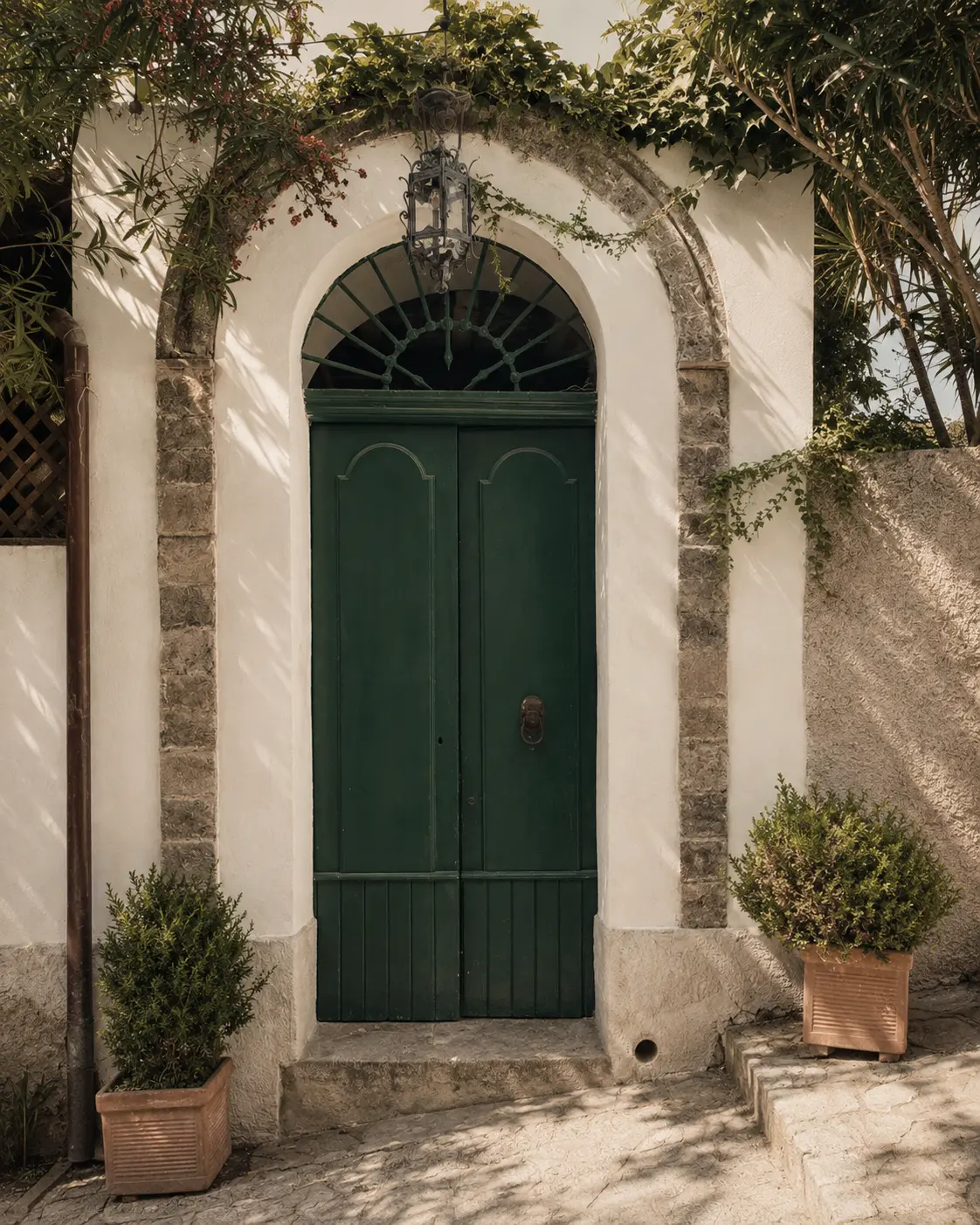 A green door in Ravello framed by ivy and an iron lantern — the door of someone Francesca has known for years.