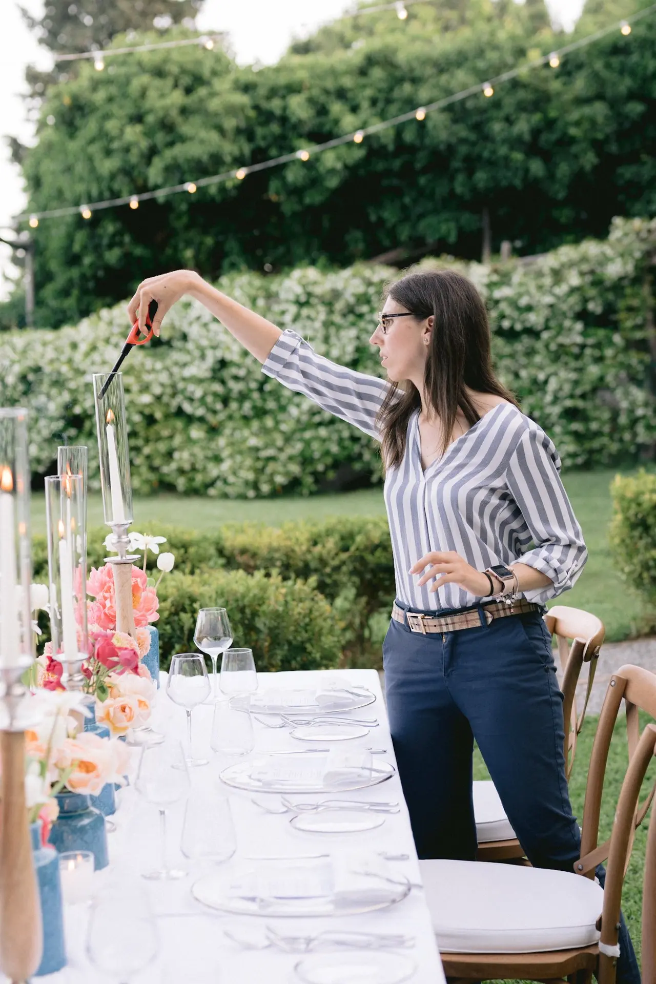 Francesca adjusting a candle at a wedding reception table on the Amalfi Coast