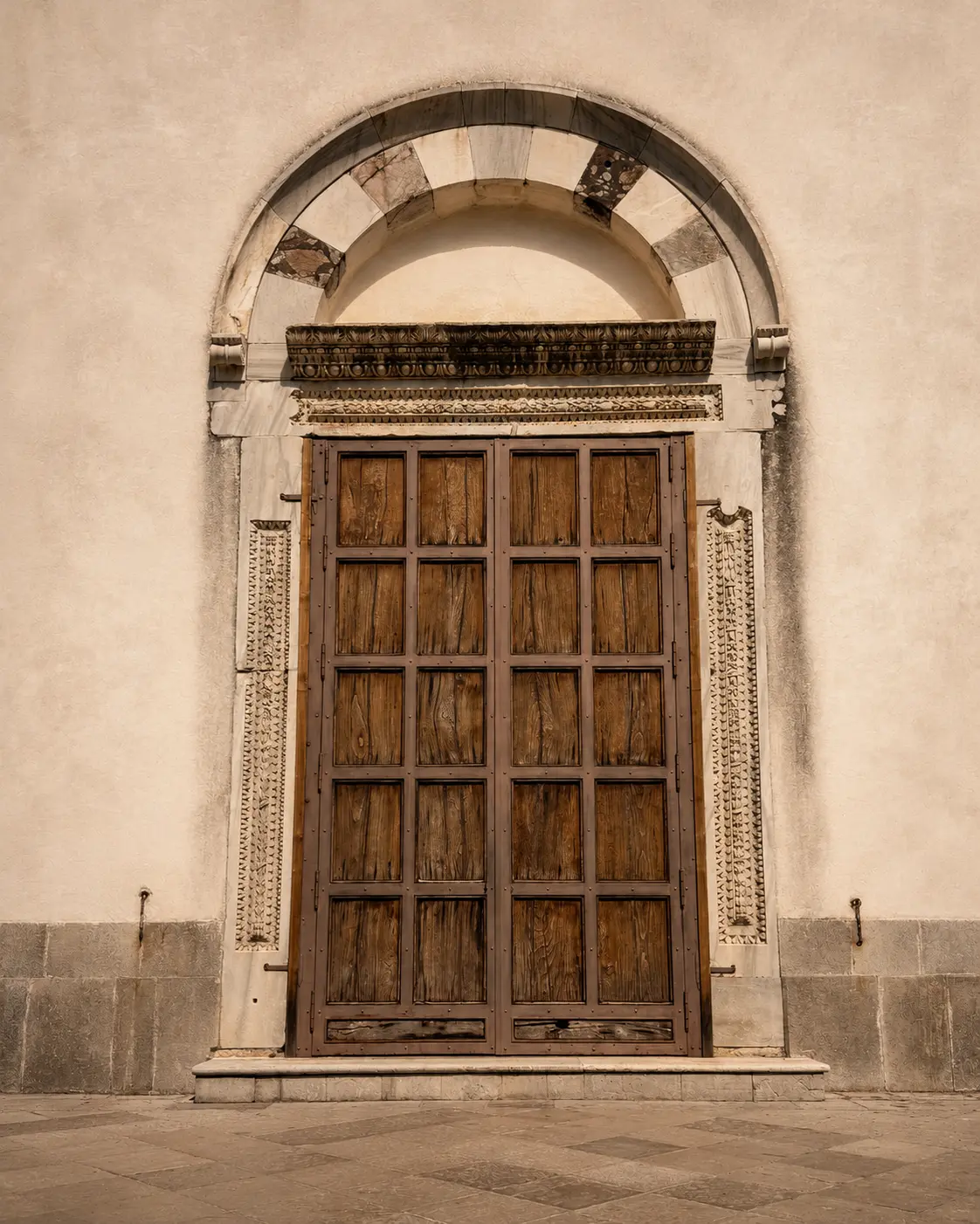 A grand panelled door beneath a carved marble archway on the Amalfi Coast — the wedding day itself.
