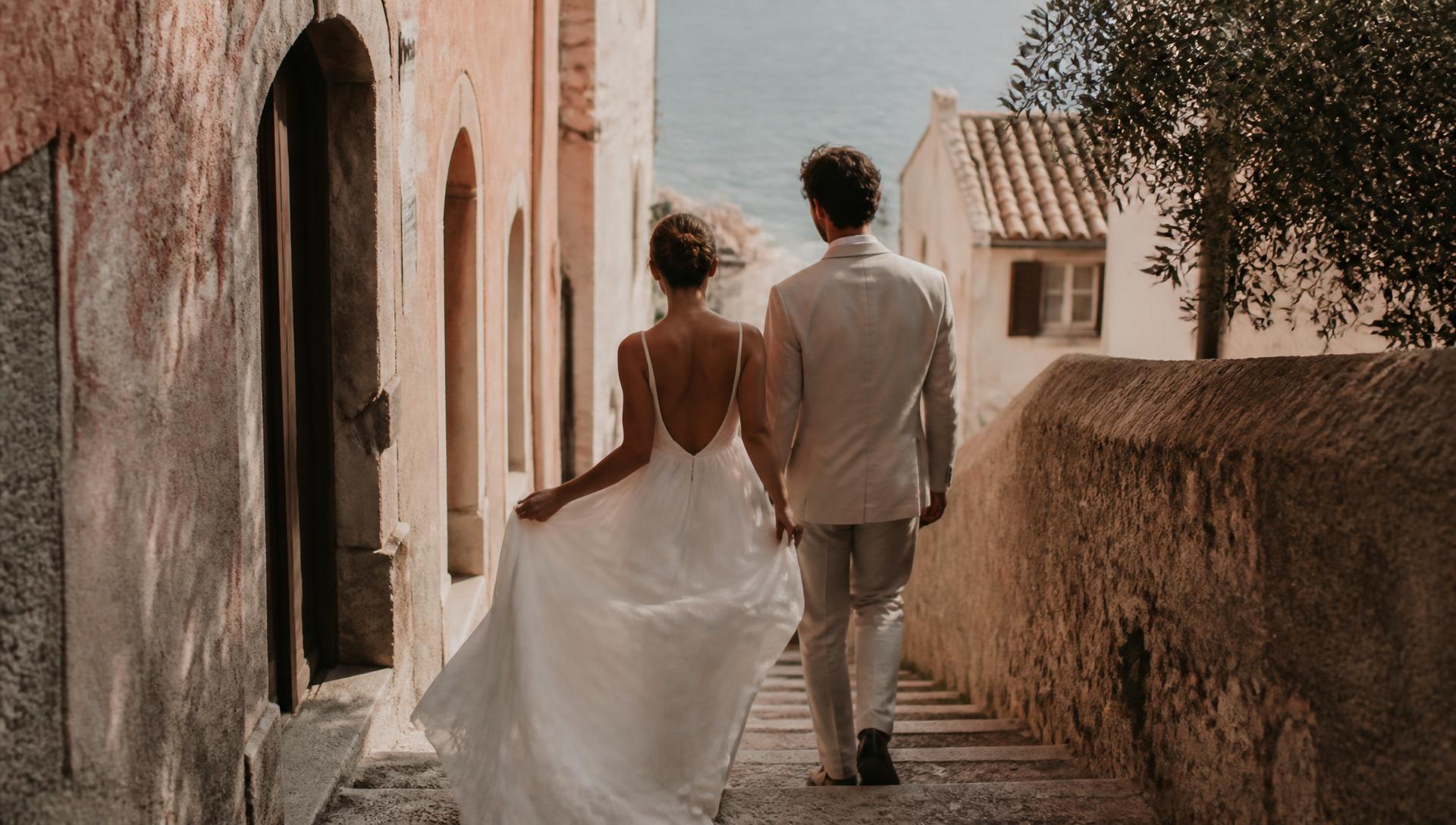 A couple walking down a stone stairway in an Italian coastal village